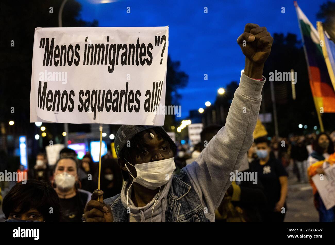 Madrid, España. 15 de noviembre de 2020. ¿un hombre levantando su puño llevando un cartel que dice "menos migrantes? menos los saquean durante una protesta contra el racismo y la xenofobia. Crédito: Marcos del Mazo/Alamy Live News Foto de stock