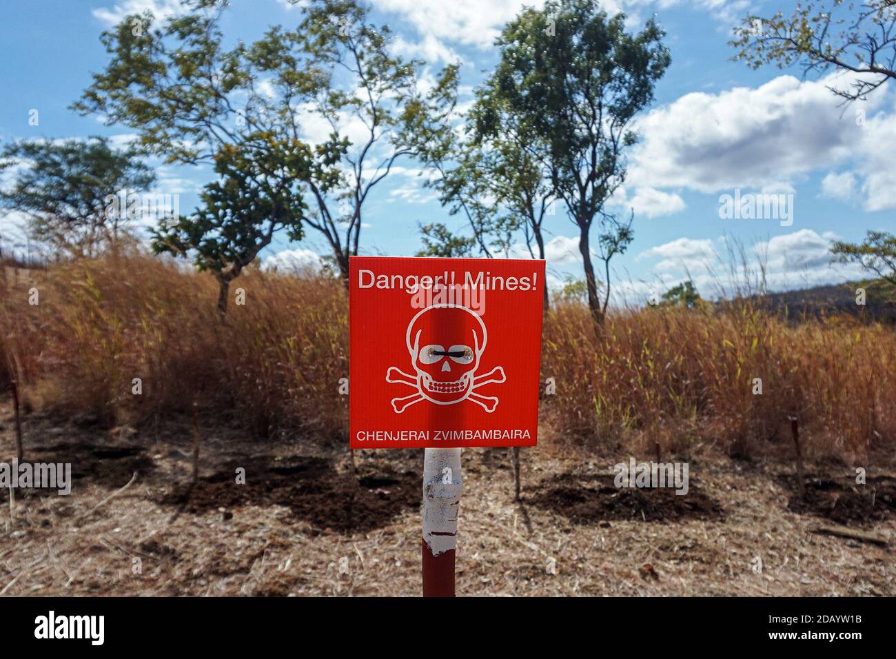 Un cartel, presentado tanto en inglés como en shona, advierte a la gente  que debe tener cuidado con las minas terrestres en Rushinga, una zona de  Zimbabwe cerca de la frontera con