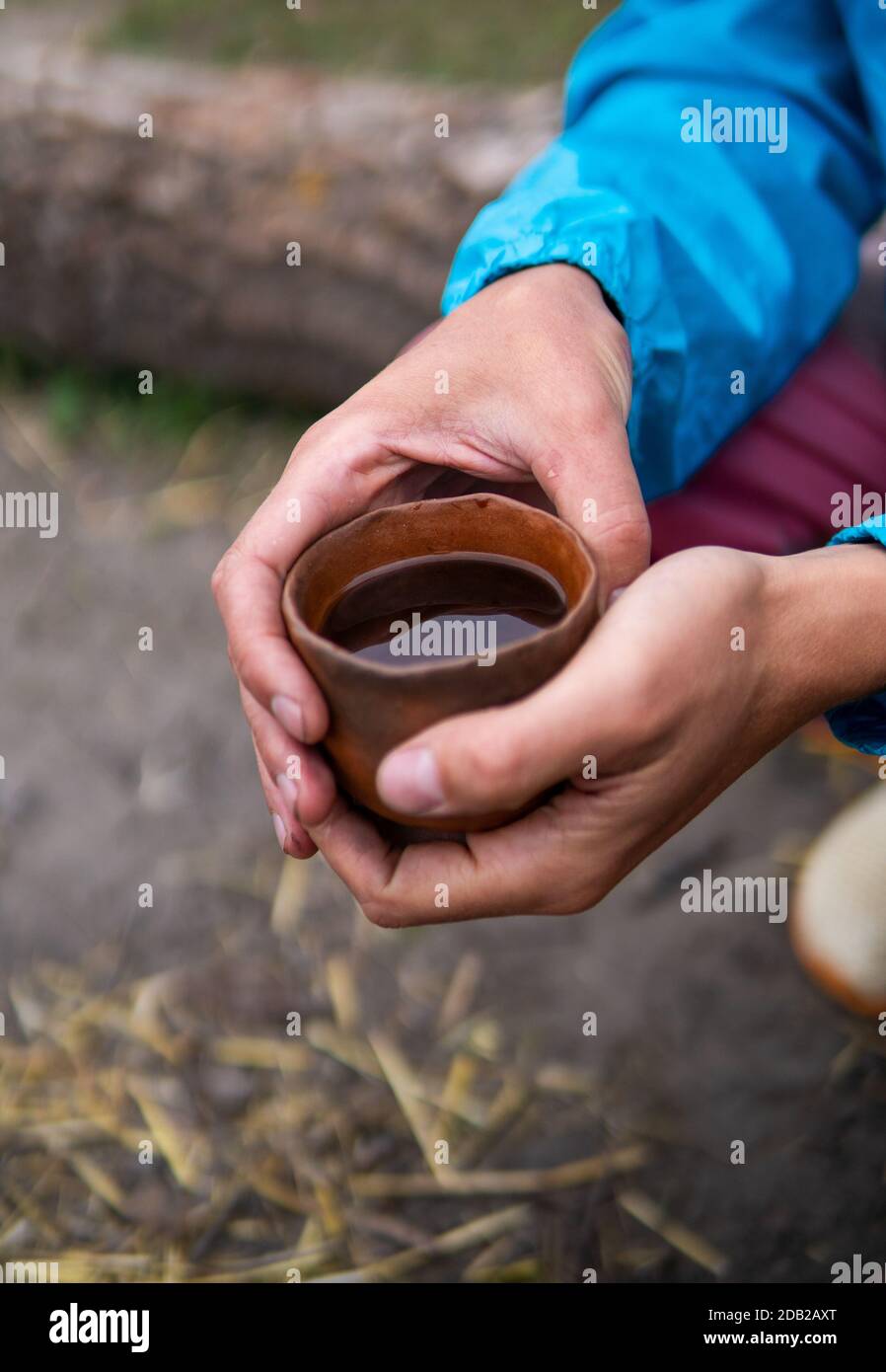Beber té chino Pu Erh al aire libre cerca del horno de fogata en  Ecovillage. Té de arcilla, taza y olla en la pequeña mesa de madera  Fotografía de stock - Alamy