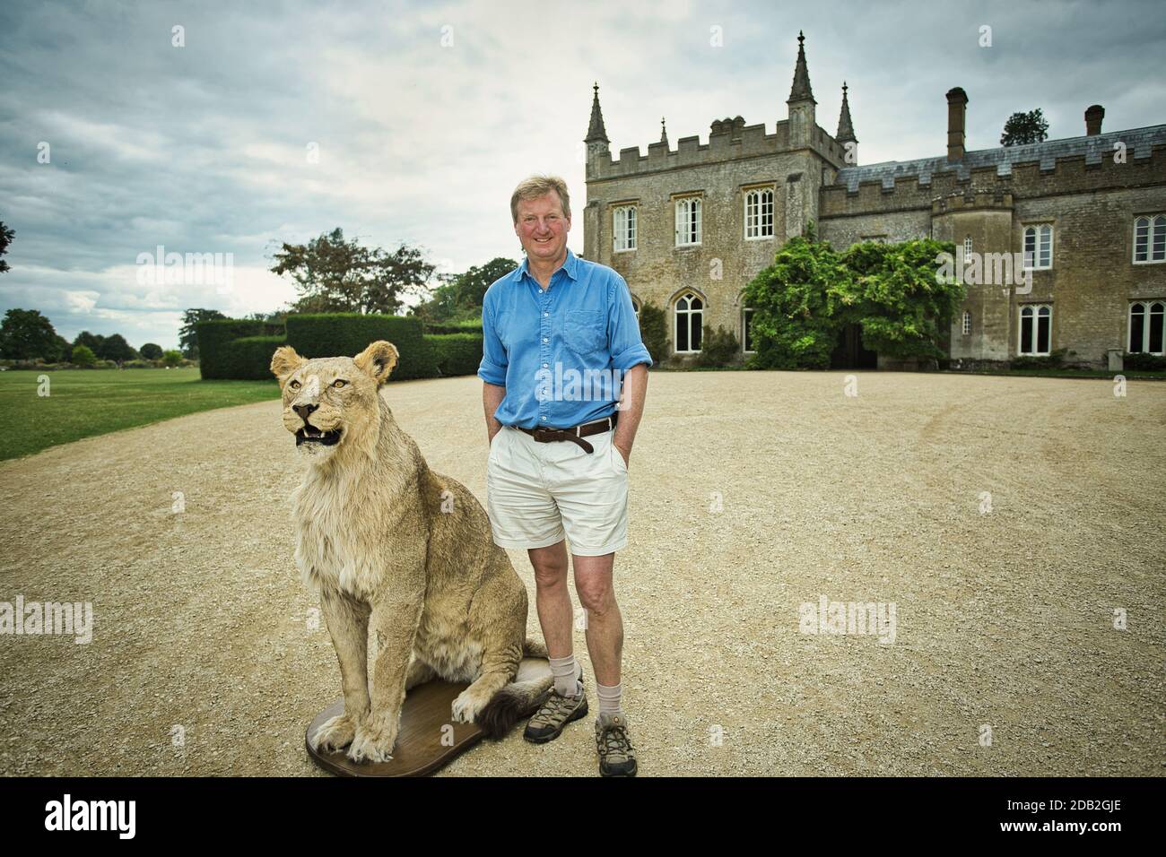GRAN BRETAÑA / Inglaterra / Oxfordshire / Cotswold Wildlife Park / Reggie Heyworh posando con León relleno Foto de stock