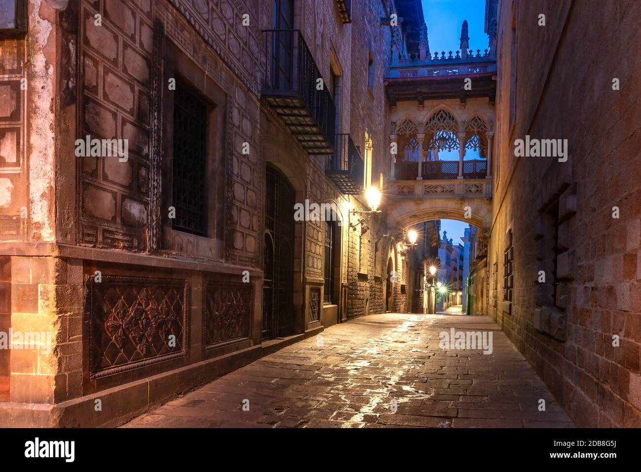 Angosta calle del Bisbe medievales adoquinadas calles con el puente de los suspiros en el Barrio Gótico de la mañana, Barcelona, Cataluña, España Foto de stock