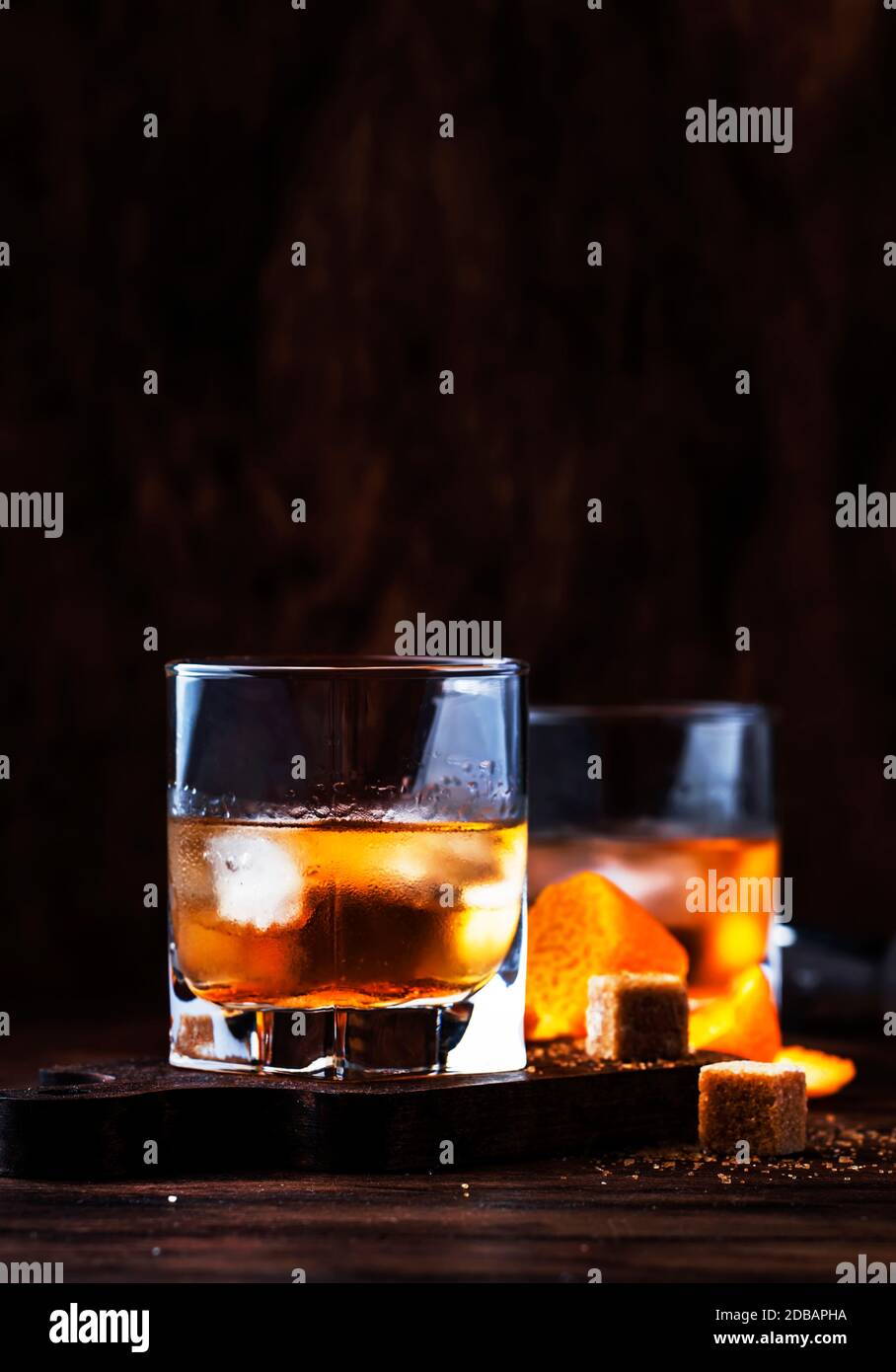 A la vieja usanza - cóctel alcohólico clásico con whisky bourbon, amargo, caña hielo en copas retro en barra de barra vintage, lugar el texto Fotografía de stock -
