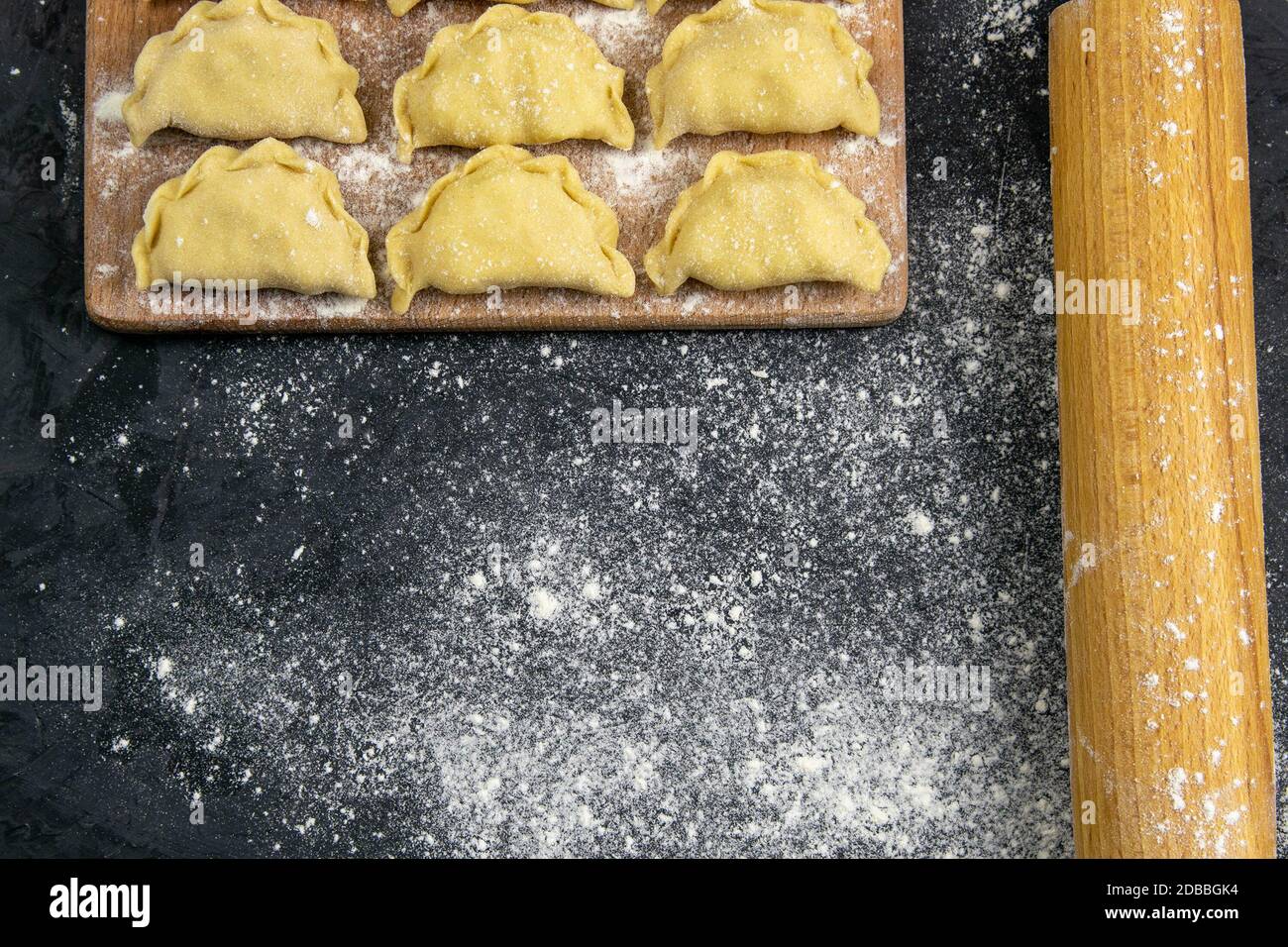 Bolas de harina en la tabla de madera junto a la mecedora para la masa