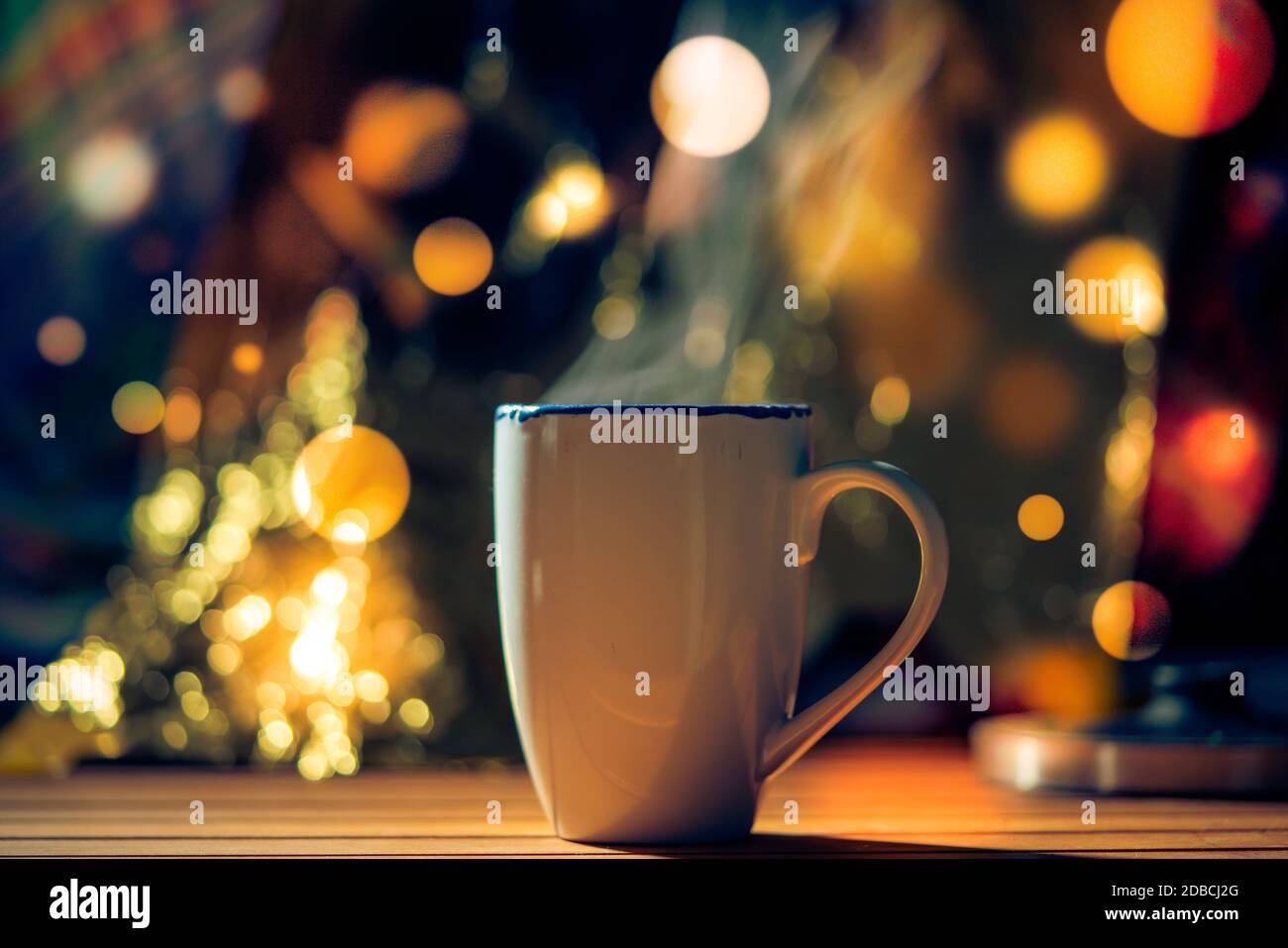 Taza con té o vino caliente sobre fondo de Navidad con bokeh Foto de stock