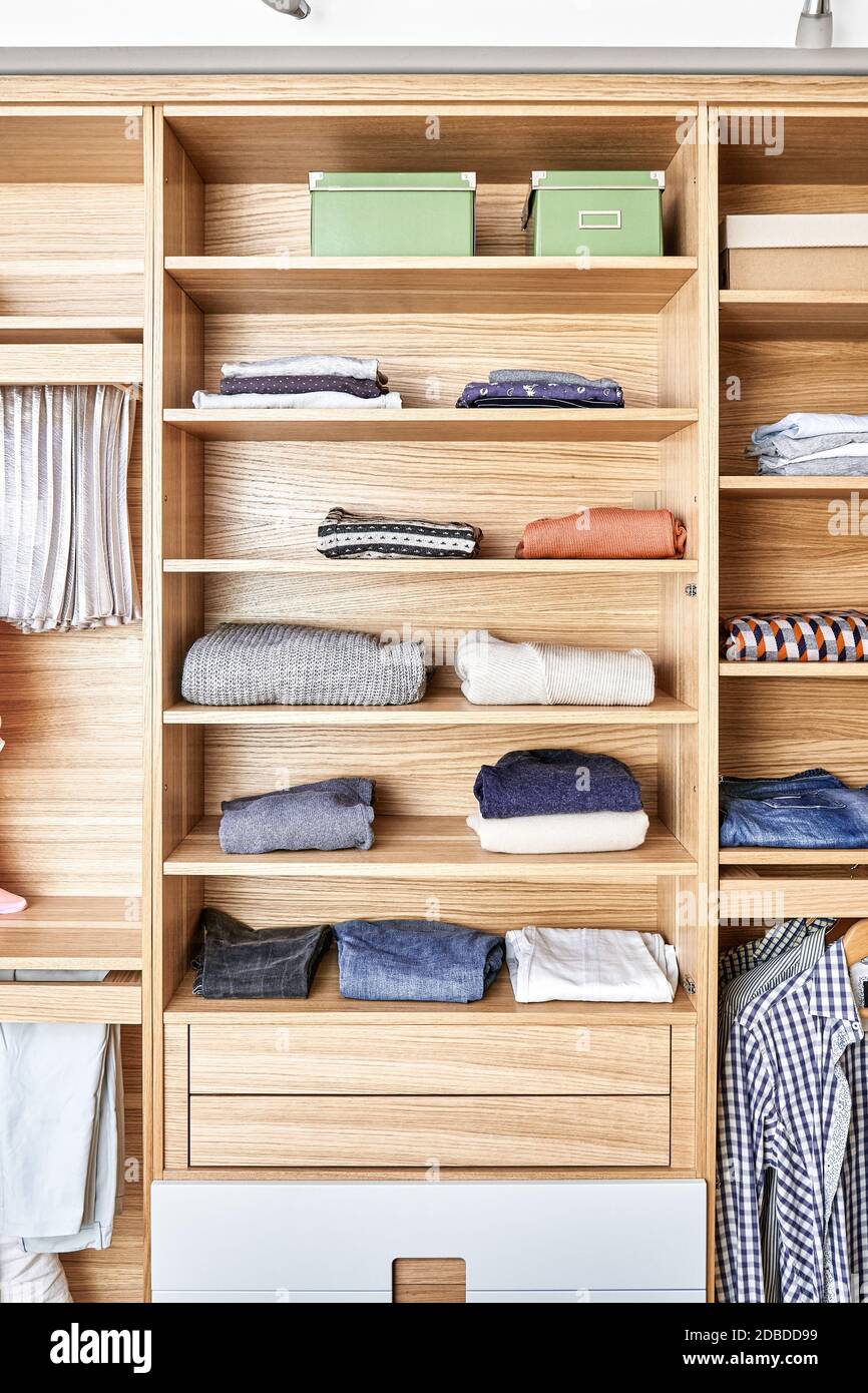 Detalles internos del armario de madera con bastidor deslizante para los  guardaparques. moderno armario con ropa colgando en los estantes deslizable  y doblada en el Fotografía de stock - Alamy