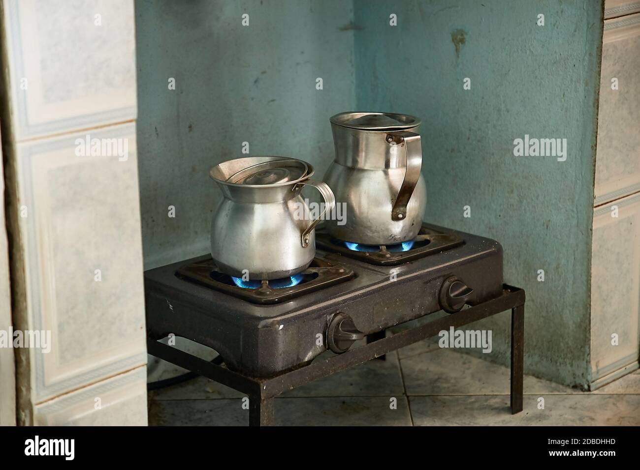 Calentar leche y agua para hacer café en un viejo estufa de metal en jarras  de metal Fotografía de stock - Alamy