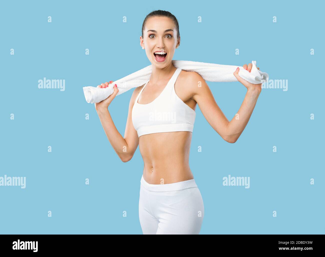 Mujer feliz de ajuste sosteniendo una toalla y posando después de hacer ejercicio, la aptitud y el concepto de ejercicio Foto de stock