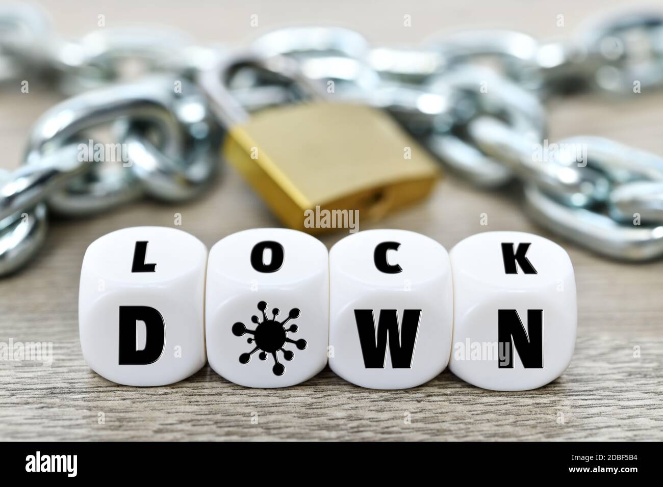 Cubos de letras que forman la palabra bloqueo frente a la cadena de hierro y candado, cierre corona Foto de stock