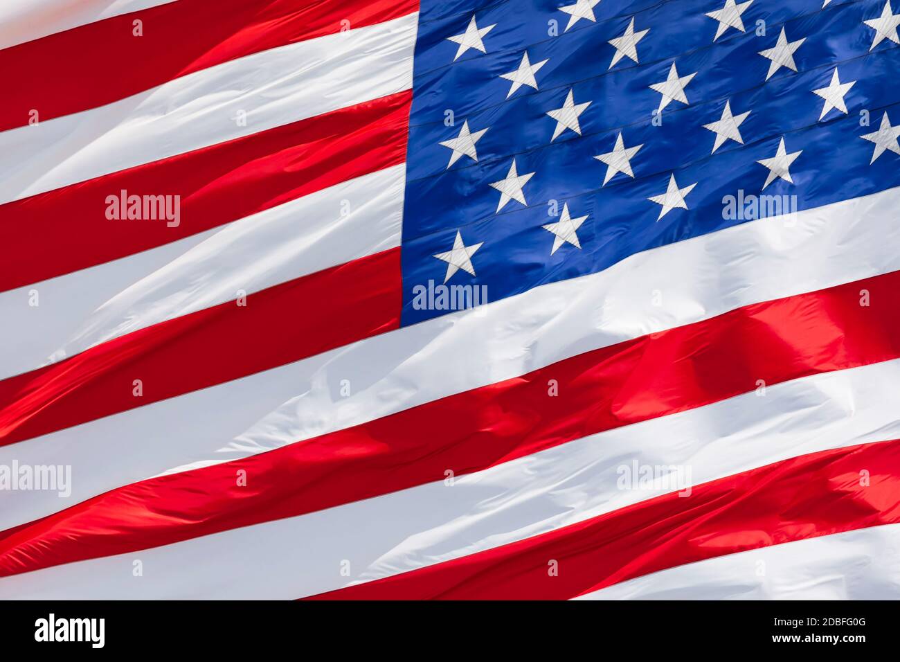 Bandera americana ondeando en el viento en el cielo azul, bandera estadounidense movimiento de cerca, bandera nacional de los Estados Unidos de América Foto de stock