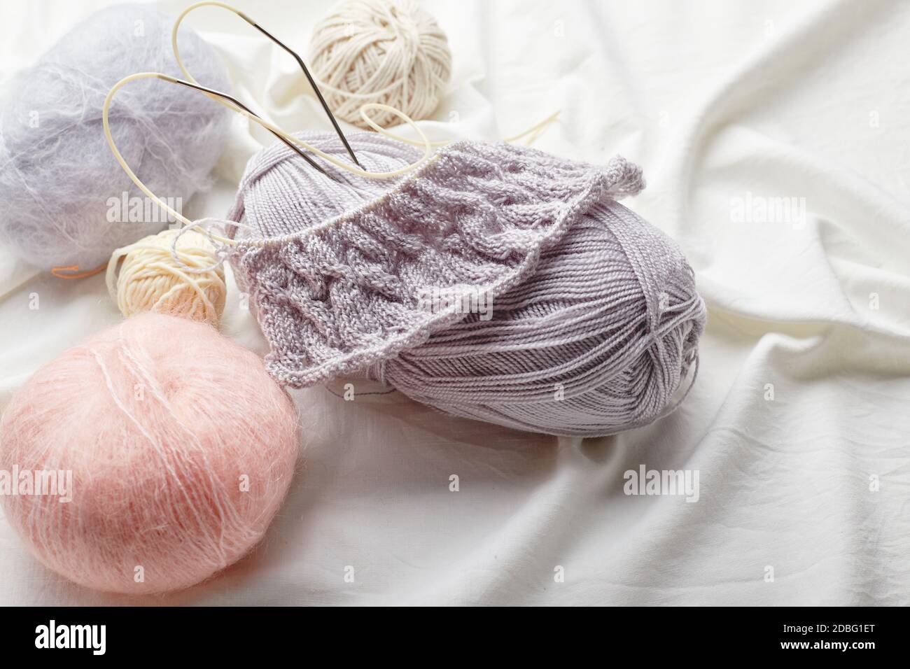 Bolas de lana y mohair para tejer en colores pastel sobre un fondo de tela  Fotografía de stock - Alamy