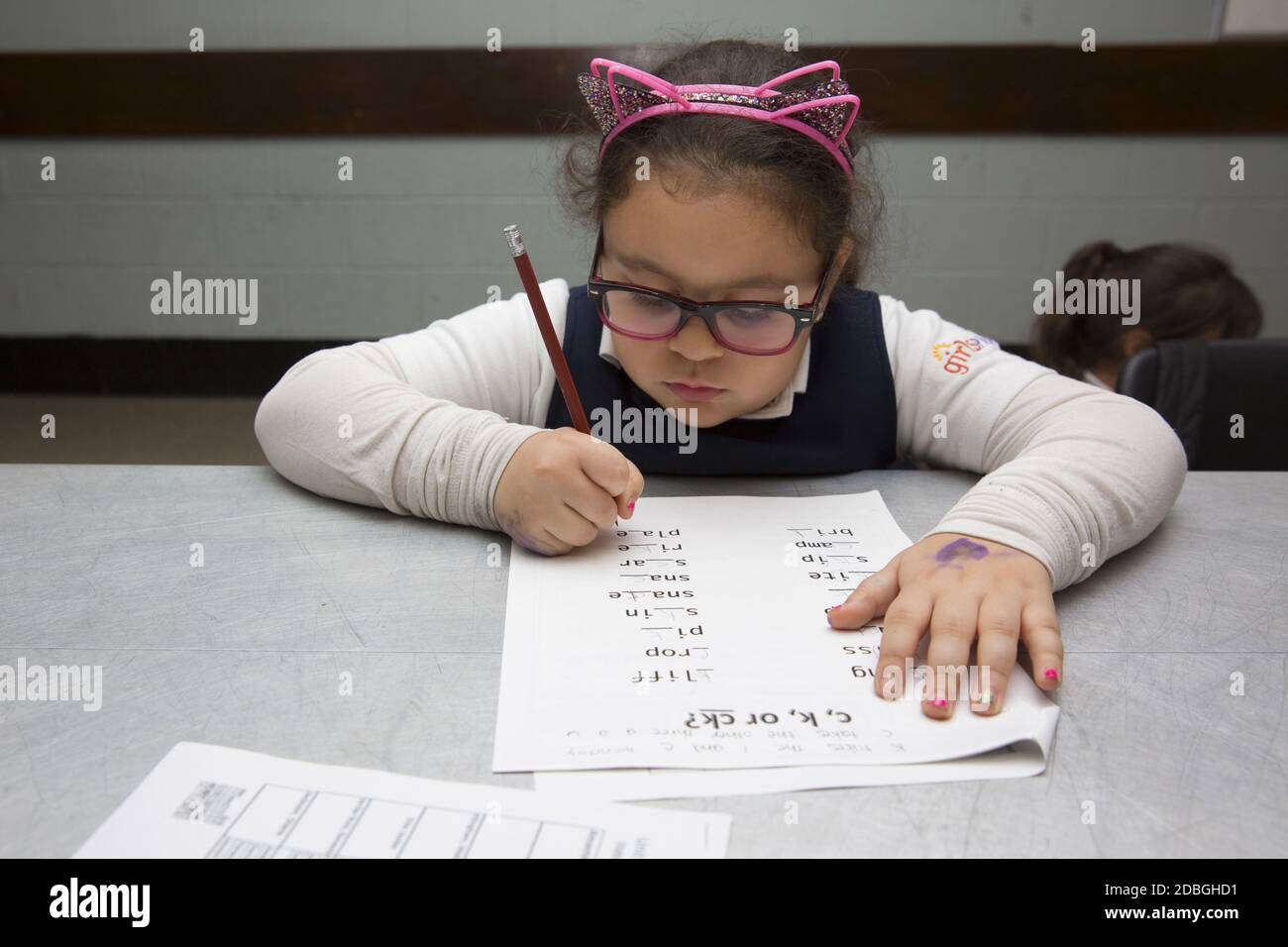 Los estudiantes de primaria trabajan en palabras de deletreo en un programa después de clases en un centro comunitario en Manhattan, Nueva York. Foto de stock