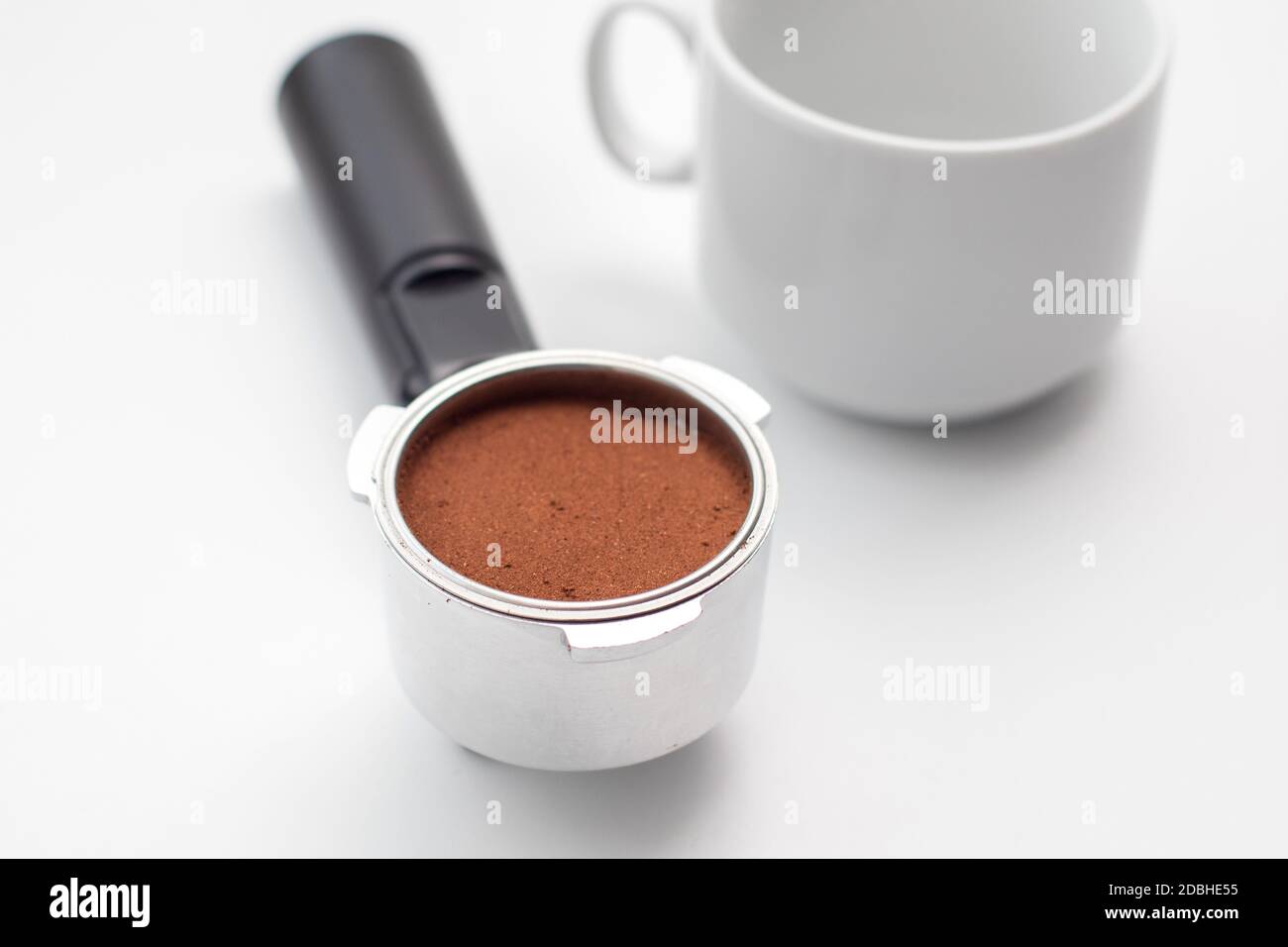 Taza blanca y soporte metálico de la cafetera con café molido en el  interior. Bocina de café y soporte del filtro de café Fotografía de stock -  Alamy