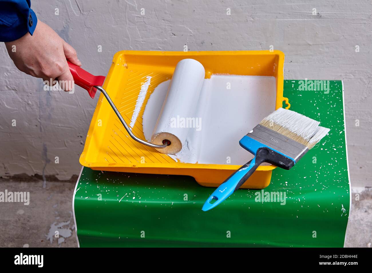 Pintor casero con rodillo de pintura en la mano va a pintar las paredes con  ayuda de herramientas de trabajo y cepillo durante la renovación Fotografía  de stock - Alamy