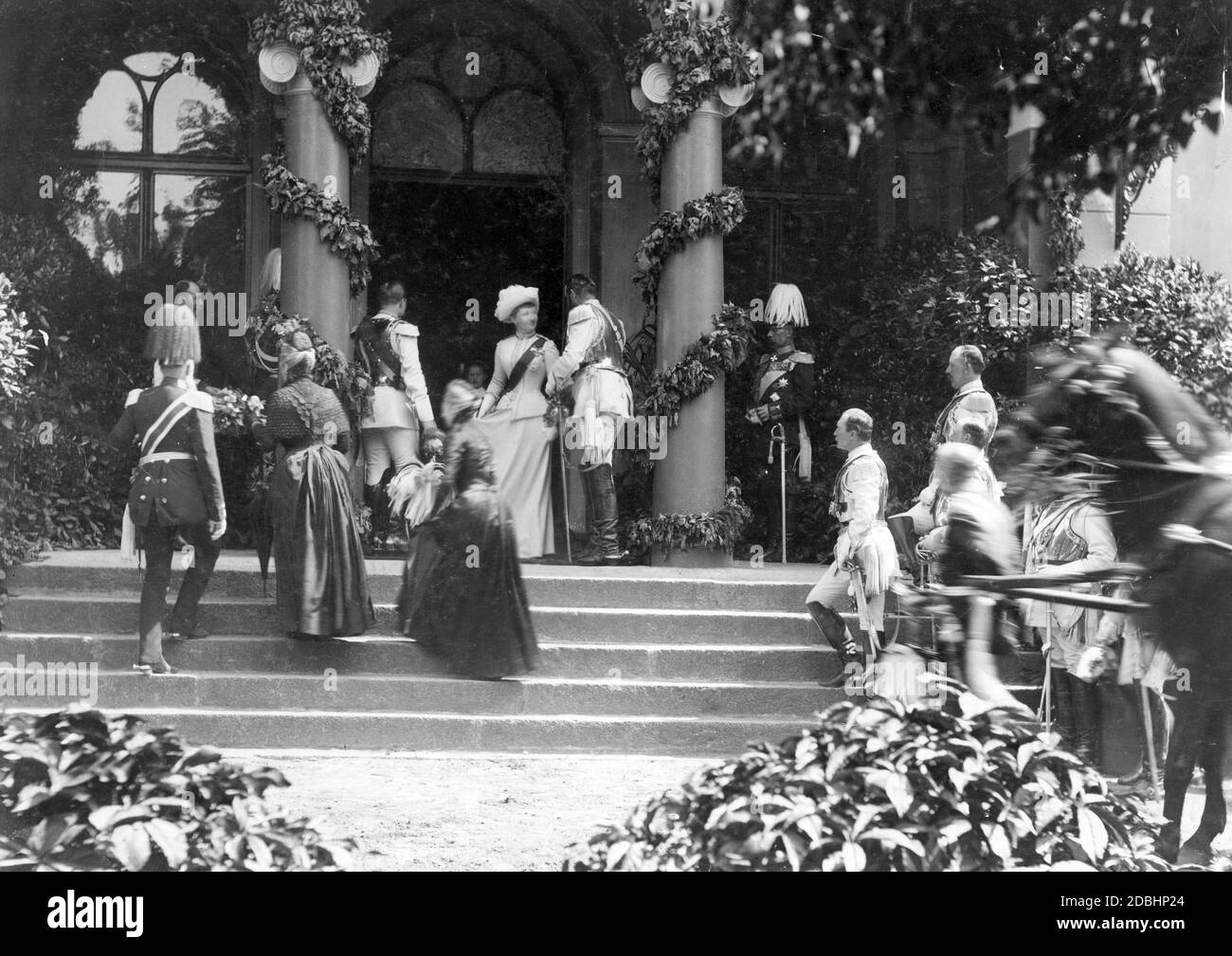 Los guardas, los oficiales y las damas caminan hacia una entrada decorada festivamente. Foto sin fecha, podría ser la boda de la princesa Victoria Louise de Prusia con Ernest Augusust de Brunswick en 1913. Foto de stock