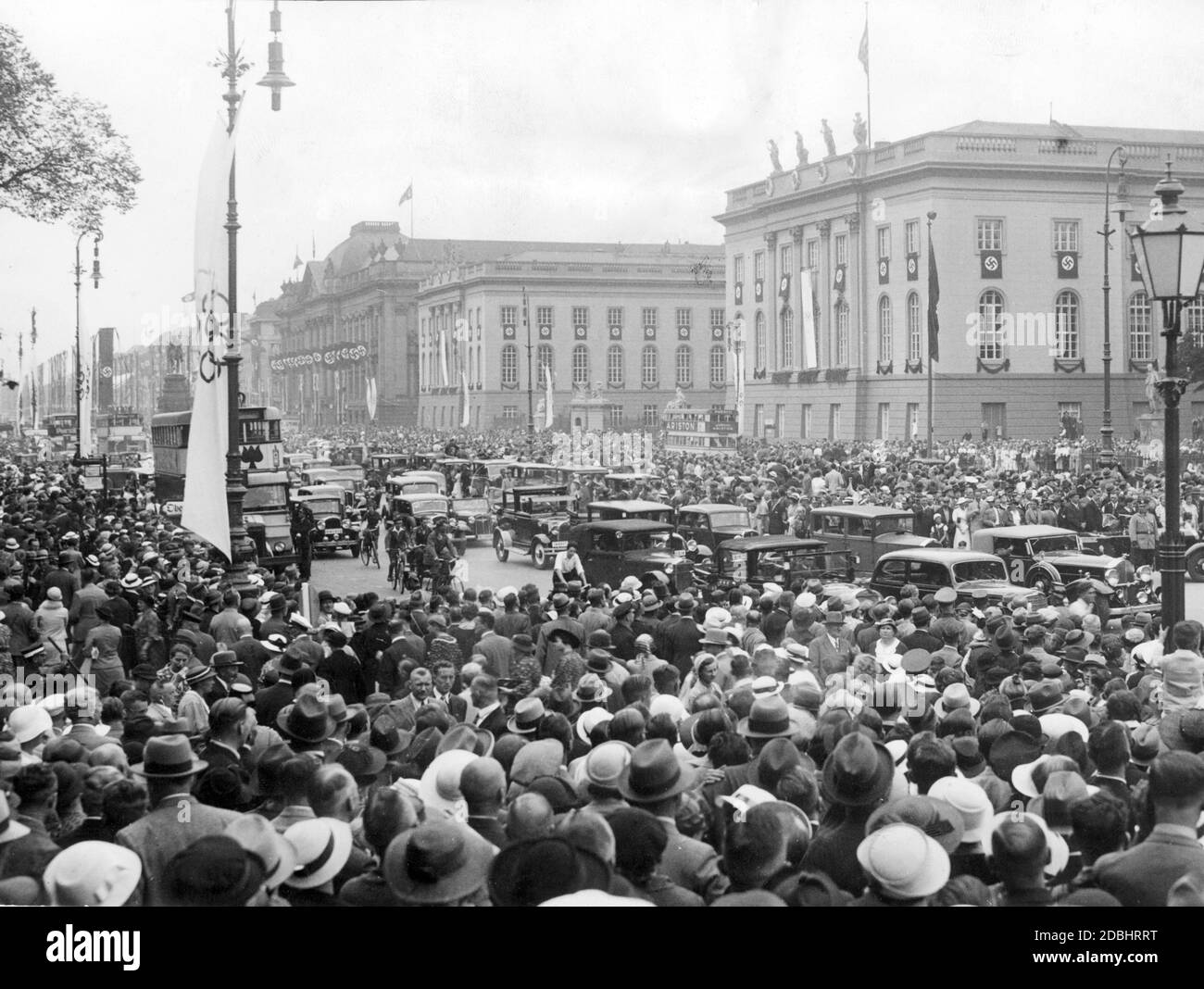 Durante las Olimpiadas de verano de agosto de 1936, multitudes se reunieron en el bulevar Unter den Linden de Berlín, en la zona de la Universidad de Humboldt (derecha) y la Biblioteca Estatal (izquierda detrás). Foto de stock