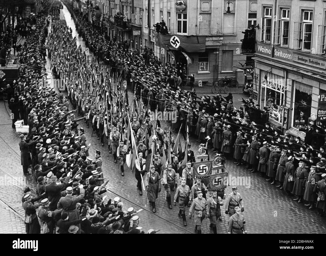 Miembros de SA durante el traslado del fallecido Landesgruppenleiter (líder del grupo nacional) Wilhelm Gustloff a través de Schwerin. Los hombres de la SA en el frente de la imagen están llevando el estándar de la SA y los hombres detrás de ellos están sosteniendo banderas de tormenta. Foto de stock