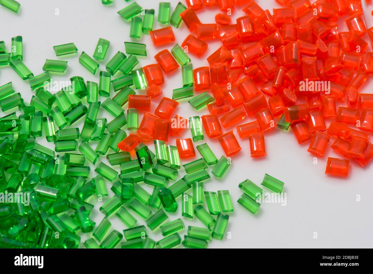 el polímero transparente rojo y verde granulan sobre fondo blanco Foto de stock