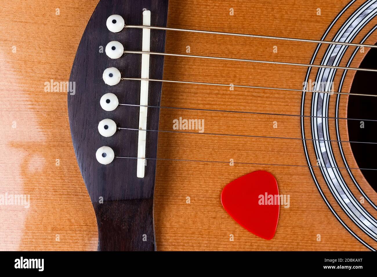 selección de guitarra amarilla metida en cuerdas de guitarra acústica de oro  en un tablero de madera oscura Fotografía de stock - Alamy