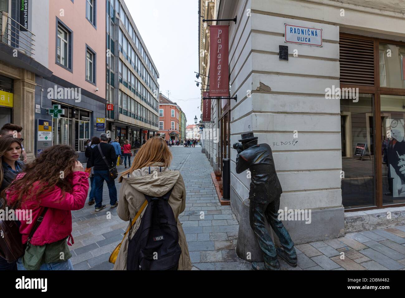 Turistas haciendo fotos a Paparazzi Estatua de un fotógrafo peinando con su cámara a la vuelta de la esquina de Radničná, Ciudad Vieja, Bratislava, Eslovaquia Foto de stock
