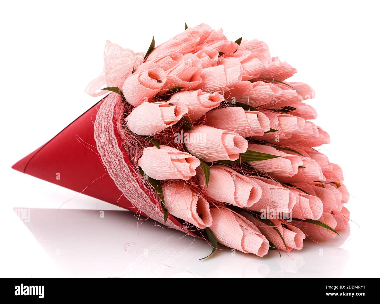 Tulipanes rosados hechos de papel corrugado en una envoltura roja con encaje  sobre un fondo blanco. Dentro de las flores hay dulces. Ramo de flores.  Hecho a mano. De cerca Fotografía de