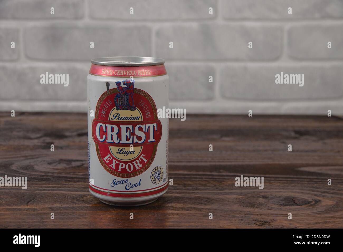 Una vieja lata de aluminio de la cerveza Crest Gran Bretaña contra la pared de ladrillo Foto de stock