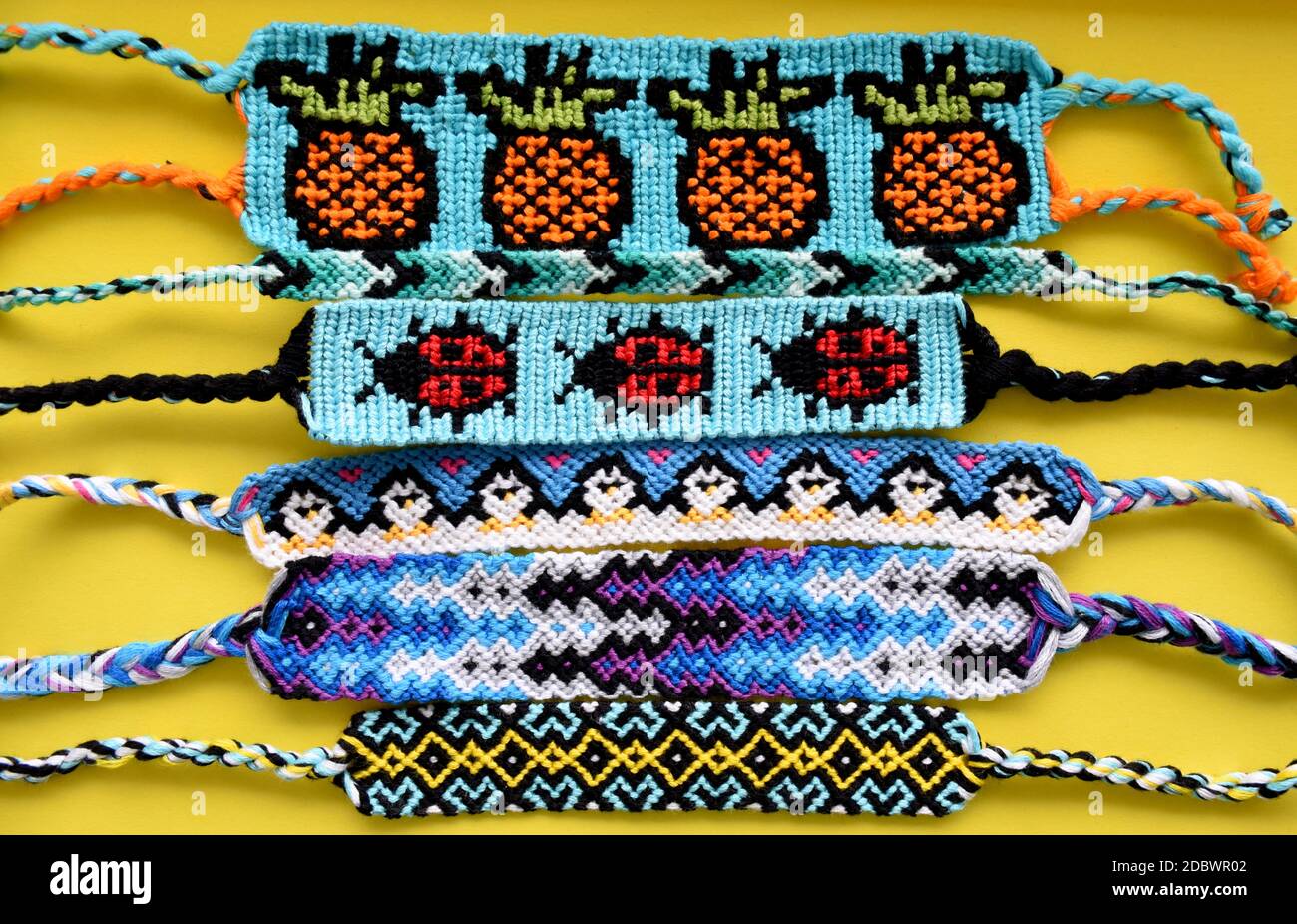 pulseras de amistad tejidas atadas de bricolaje hechos a mano de bordado hilo brillante con nudos en fondo amarillo. y patrones Fotografía de stock - Alamy