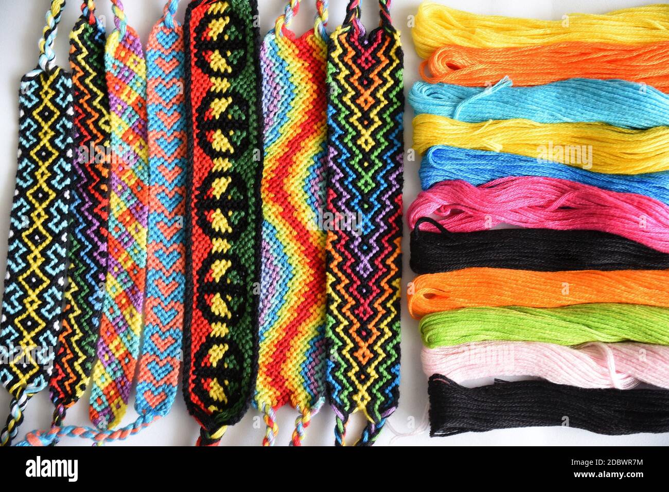 Pulseras de amistad tejidas hechas a mano con un colorido patrón brillante  skeins de hilo sobre fondo blanco Fotografía de stock - Alamy