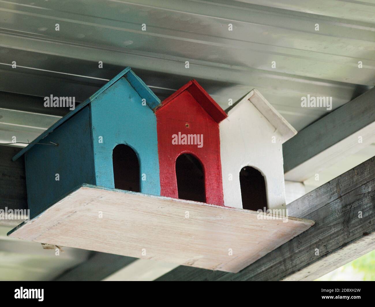 Una foto en color de tres coloridas casas de pájaros Foto de stock
