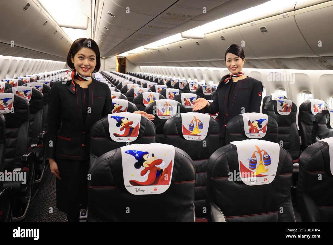 Tokio, Japón. 18 de noviembre de 2020. Los asistentes de cabina de Japan  Airlines (JAL) exhiben cubiertas de reposacabezas de diseño especial en un  avión diseñado especialmente para celebrar el 80º aniversario