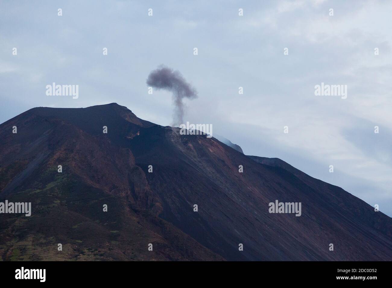 Sicilia, Italia. Una pluma oscura de humo volcánico y cenizas se levanta del volcán activo de Stromboli. Foto de stock