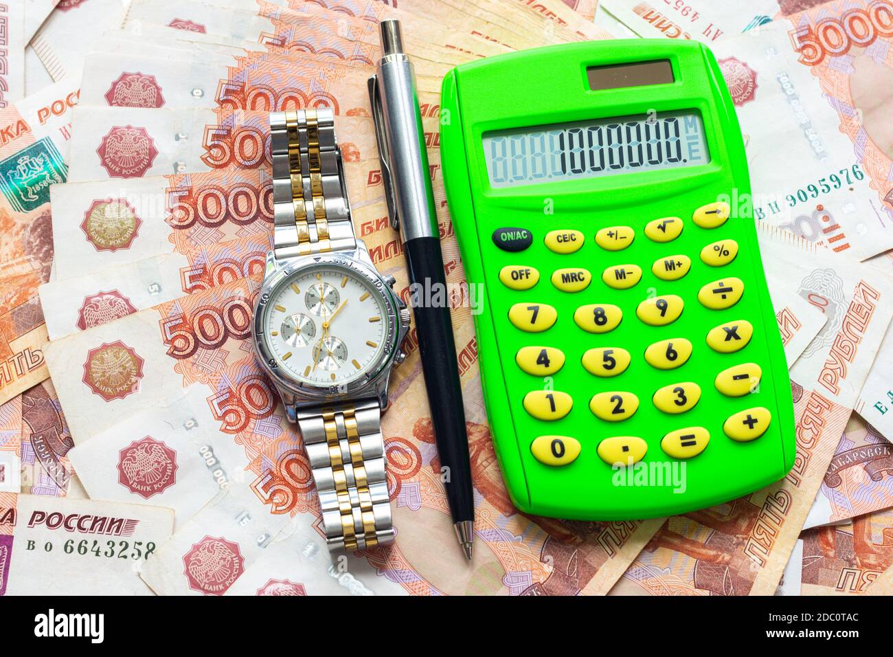 En el fondo de los cinco mil proyectos de ley rusos se encuentra una  calculadora con el número un millón, un reloj y un bolígrafo Fotografía de  stock - Alamy