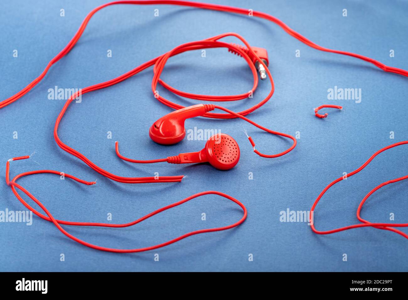 Auriculares sobre fondo azul. Auriculares rotos. Reparación de dispositivos  electrónicos. Cable roto Fotografía de stock - Alamy