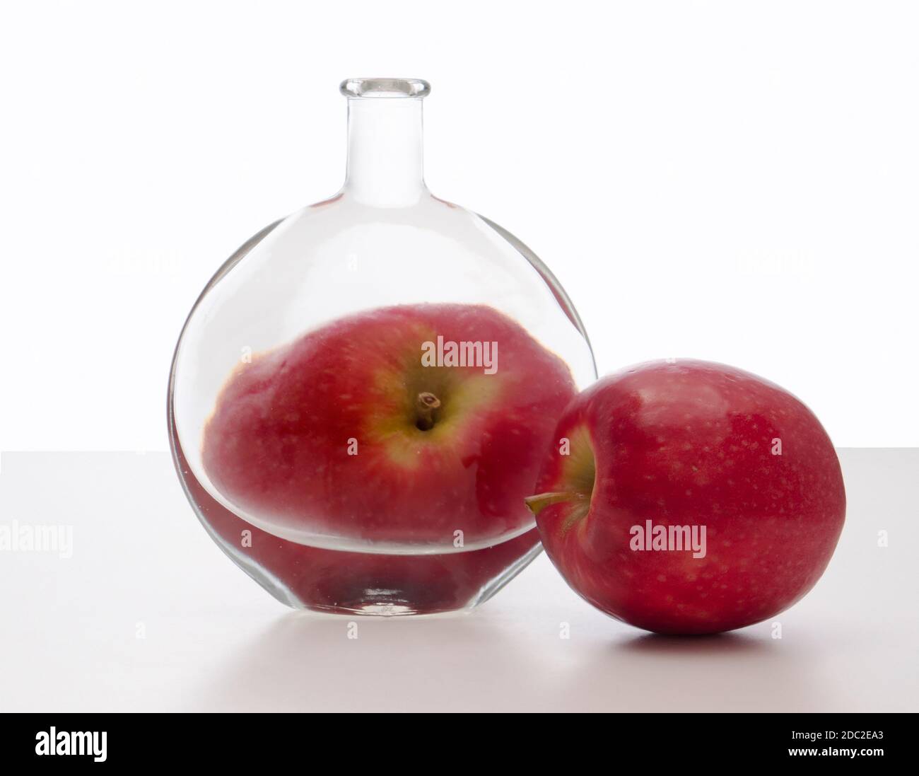 Distorsión, refracción a través de agua y botella. Con manzana. Foto de stock