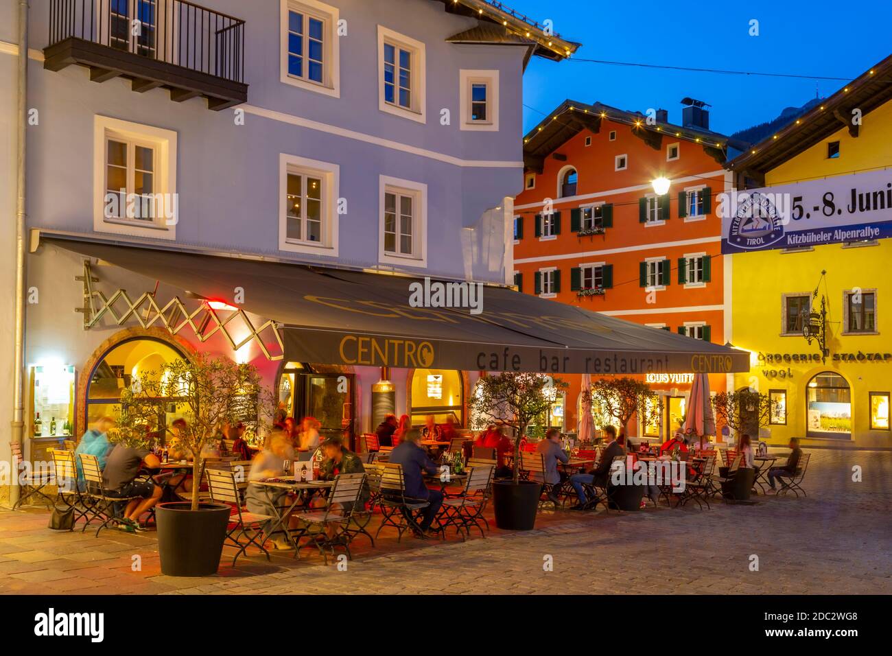 Vista de los visitantes disfrutando de bebidas fuera del café en Vorderstadt al atardecer, Kitzbuhel, Región del Tirol austriaco, Austria, Europa Foto de stock