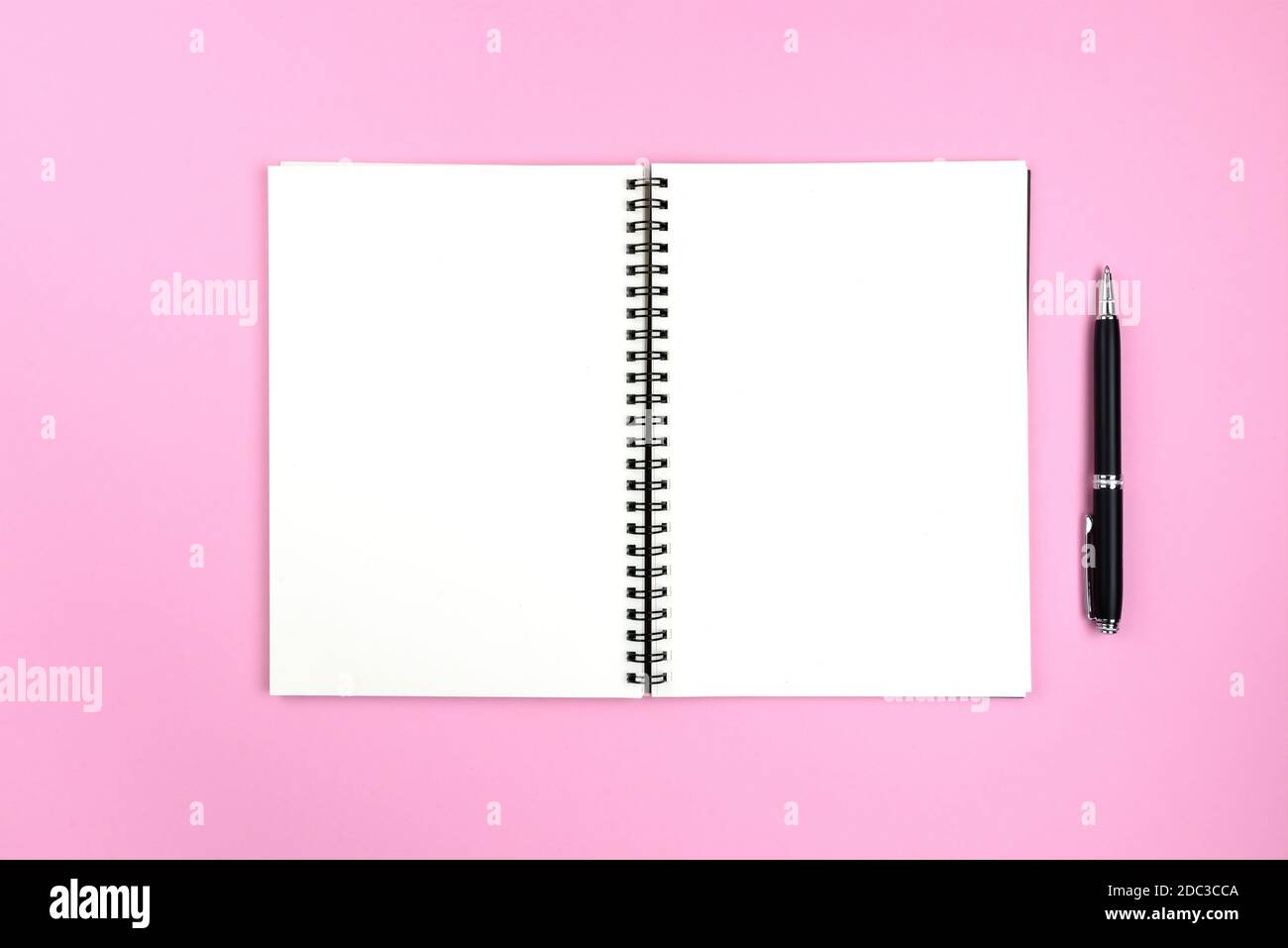páginas en blanco de bloc de notas espiral abierto y lápiz sobre rosa antecedentes Foto de stock