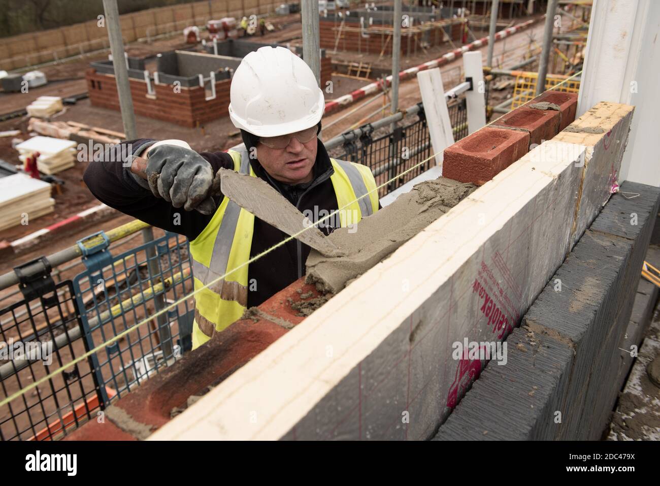 Bricklayer en el trabajo en un sitio de la vivienda del Reino Unido Foto de stock