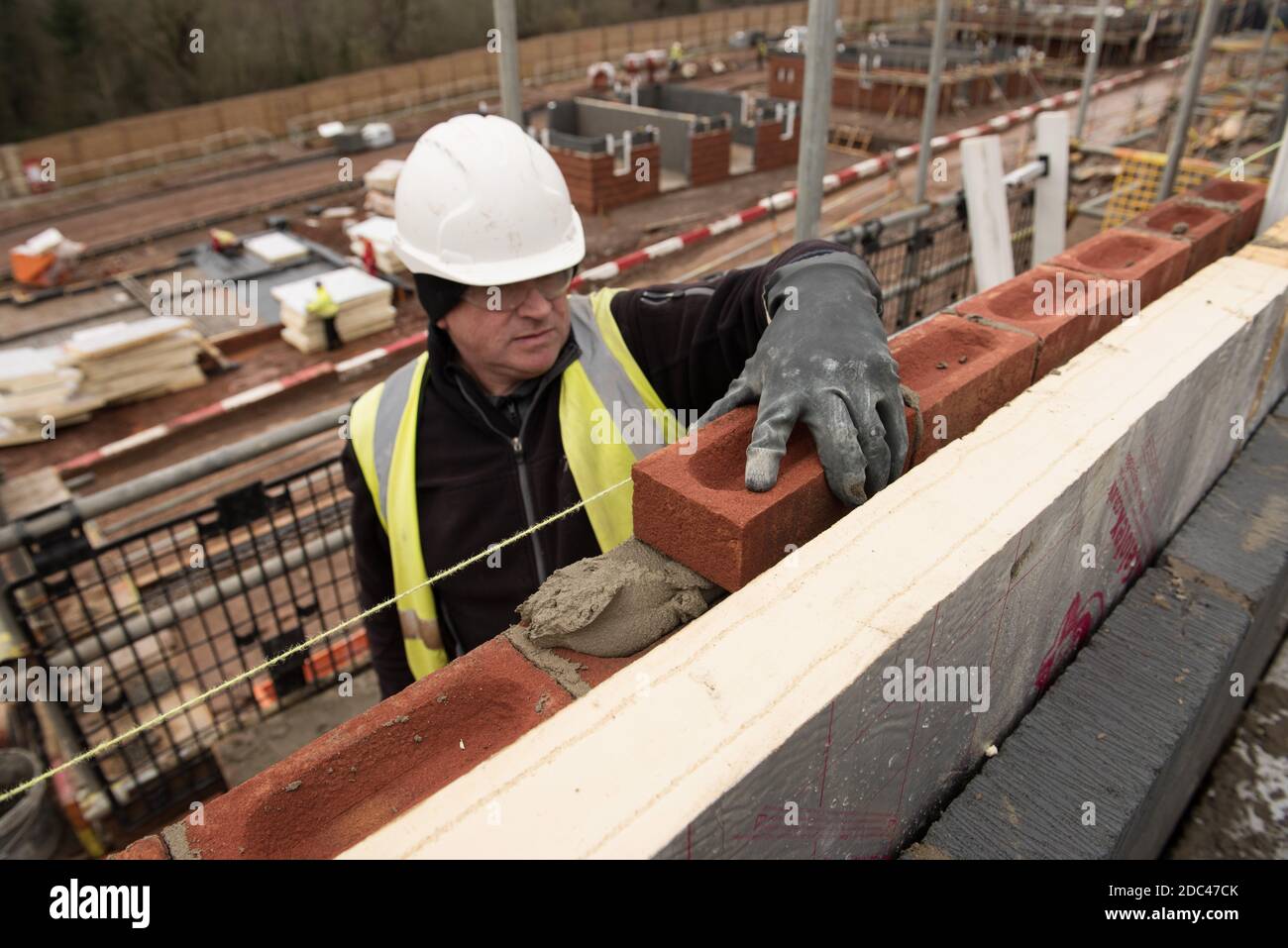 Bricklayer en el trabajo en un sitio de la vivienda del Reino Unido Foto de stock