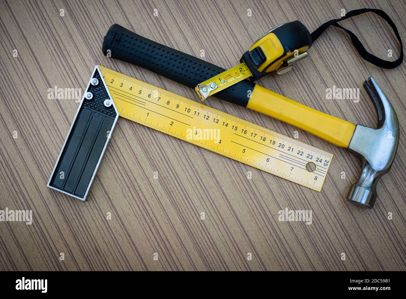 El cuadrado de la prueba del martillo y la cinta métrica son juego de la  mano herramientas para el carpintero sobre tabla de madera Fotografía de  stock - Alamy
