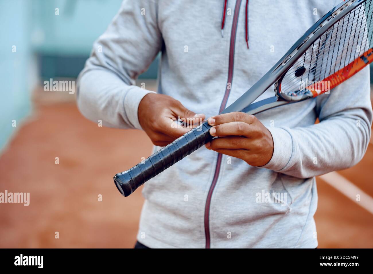El jugador de tenis irreconocible repara la cobertura del mango de la  raqueta de tenis Fotografía de stock - Alamy