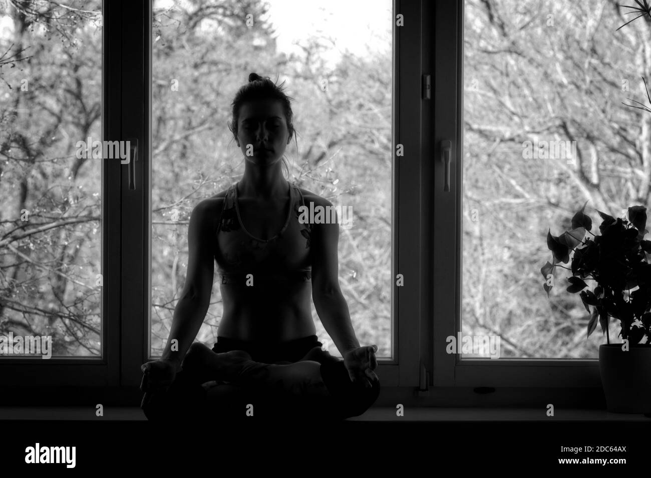 Silueta de una joven en posición de yoga Foto de stock