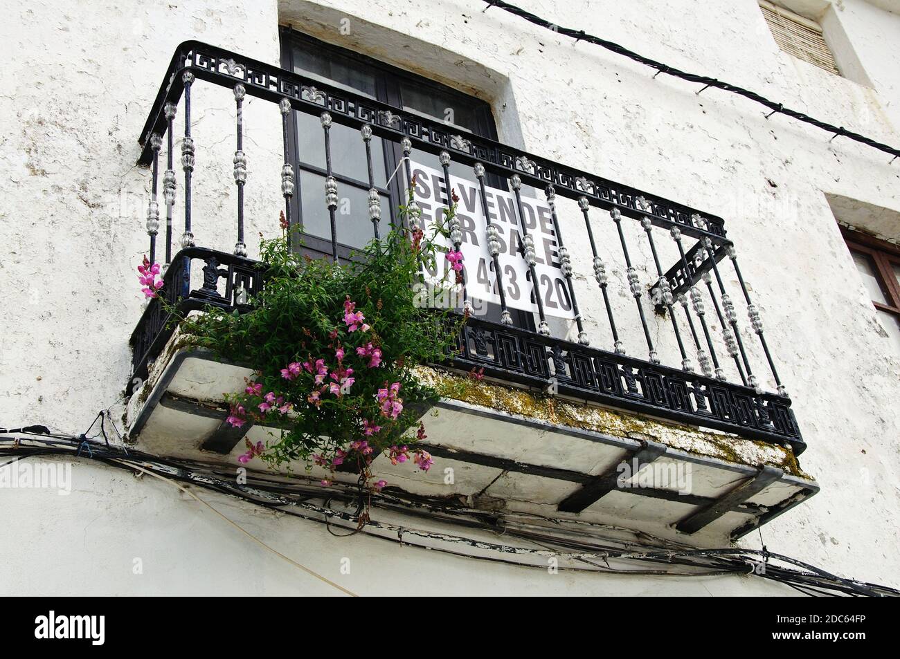 Balcón de hierro forjado y ventana signo de en una casa adosada en el casco antiguo, Casares, España Fotografía stock - Alamy