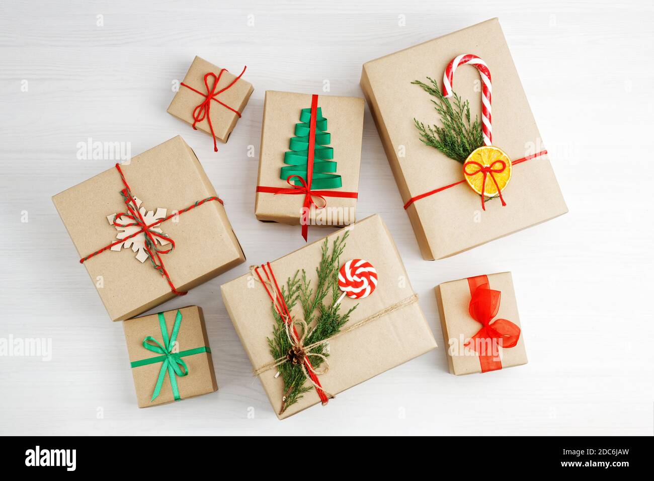 Grupo de cajas de regalo envueltas en papel kraft, atadas con hilo y con cintas sobre mesa de madera blanca de stock - Alamy