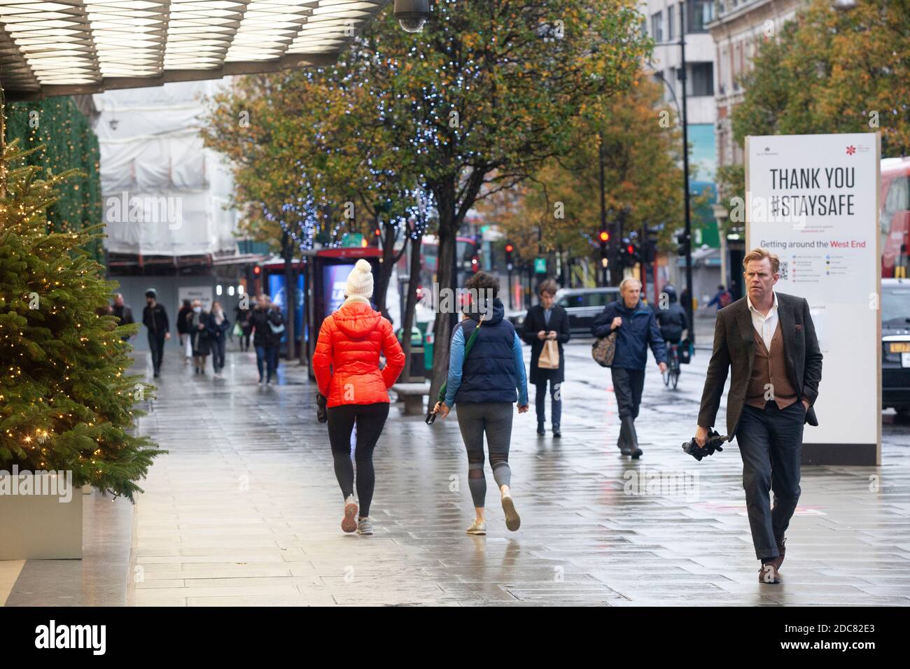 Londres, Reino Unido, 19 de noviembre de 2020: A pesar del bloqueo de Inglaterra y el clima lluvioso algunas personas van de compras o utilizan clic y recoger en el West End de Londres. Las ventanas de los grandes almacenes Selfridges son una atracción para los transeúntes. Anna Watson/Alamy Live News Foto de stock