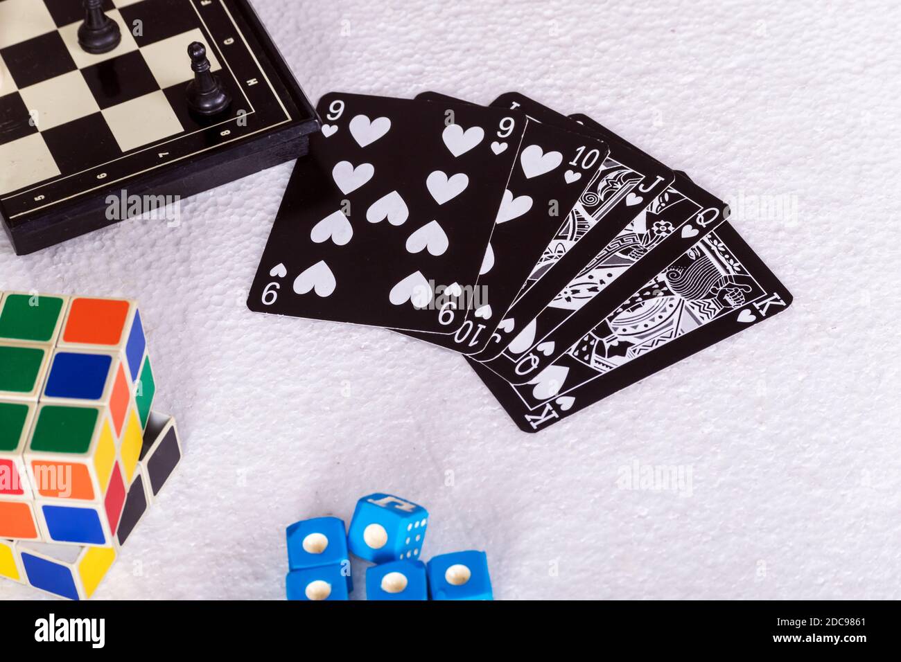 Escalera de color de póquer negro rodeado por un tablero de ajedrez, un cubo  Rubik estándar y dados azules de un juego de póquer mentira Fotografía de  stock - Alamy