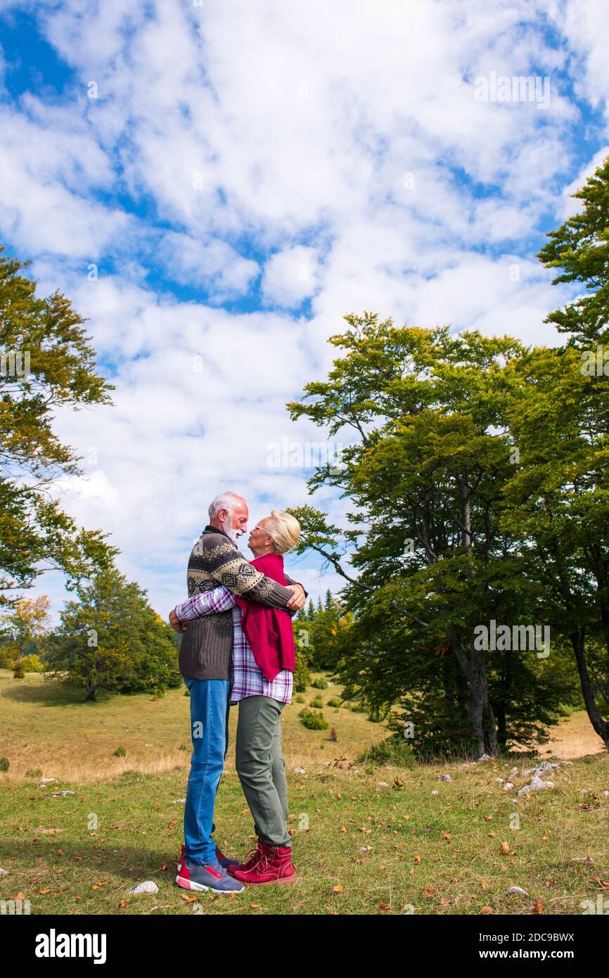 Pareja de ancianos abrazando en el parque de otoño. Disfrutar en el amor. Foto de stock