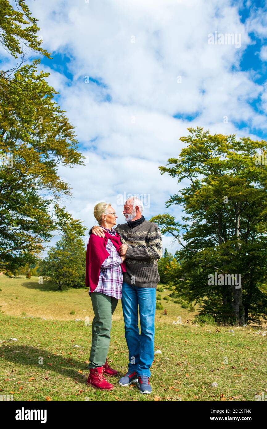Las parejas ancianas en un paseo en el otoño de la naturaleza. Foto de stock