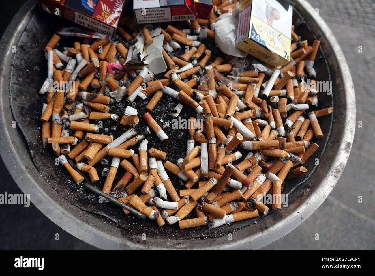 26.02.2019, Berlín, Alemania - colillas de cigarrillos y paquetes de cigarrillos vacíos en un cenicero. 00S190226D240CAROEX.JPG [VERSIÓN MODELO: NO APLICABL Foto de stock
