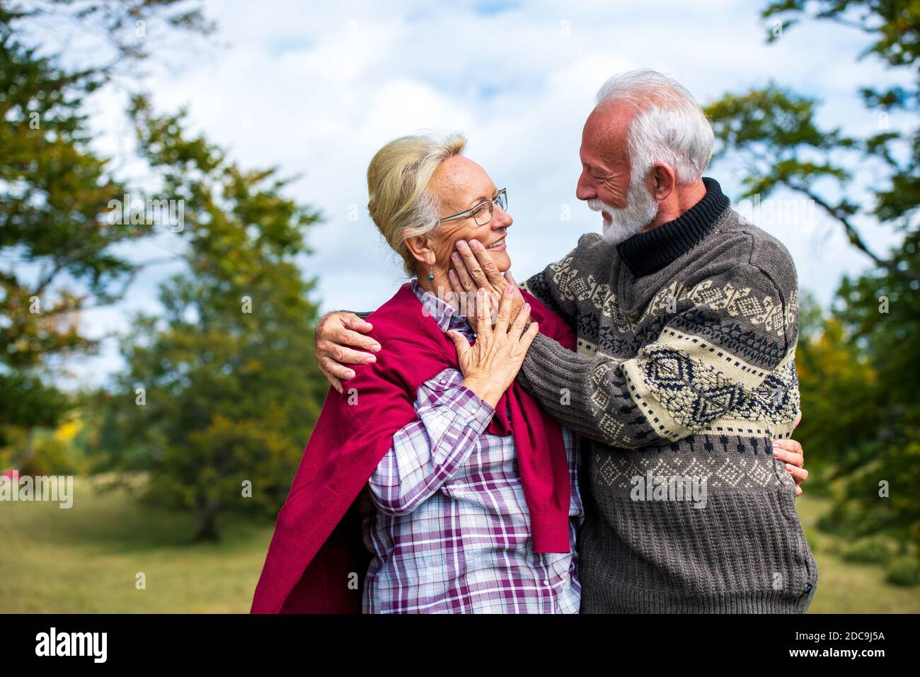 Pareja de ancianos abrazando en el parque de otoño. Disfrutar en el amor. Foto de stock