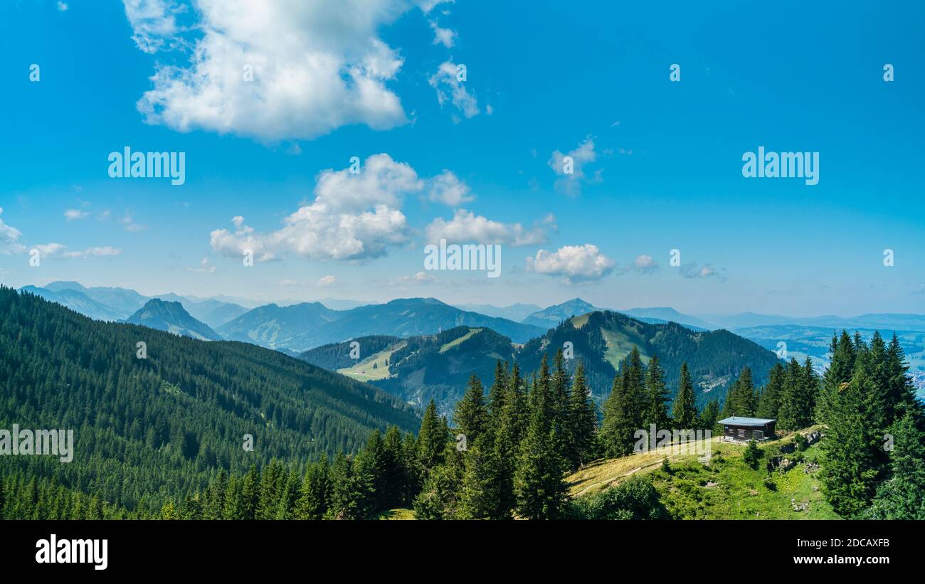 Alemania, Allgaeu, Alpspitz vista de la montaña sobre interminables montañas cubiertas de árboles verdes y valles en verano Foto de stock