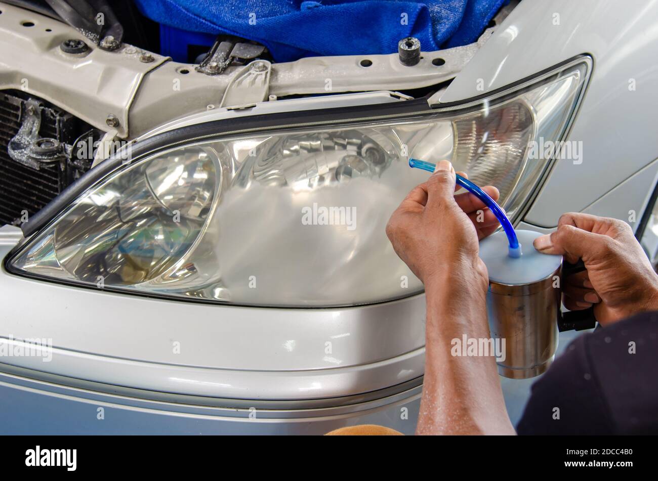 Rocíe laca para cubrir los faros del coche para hacerlos brillar Fotografía  de stock - Alamy